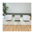Three white bedside tables with different stone-patterned tops and legs