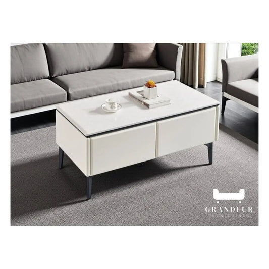 White storage coffee table with black legs positioned in front of a grey sofa
