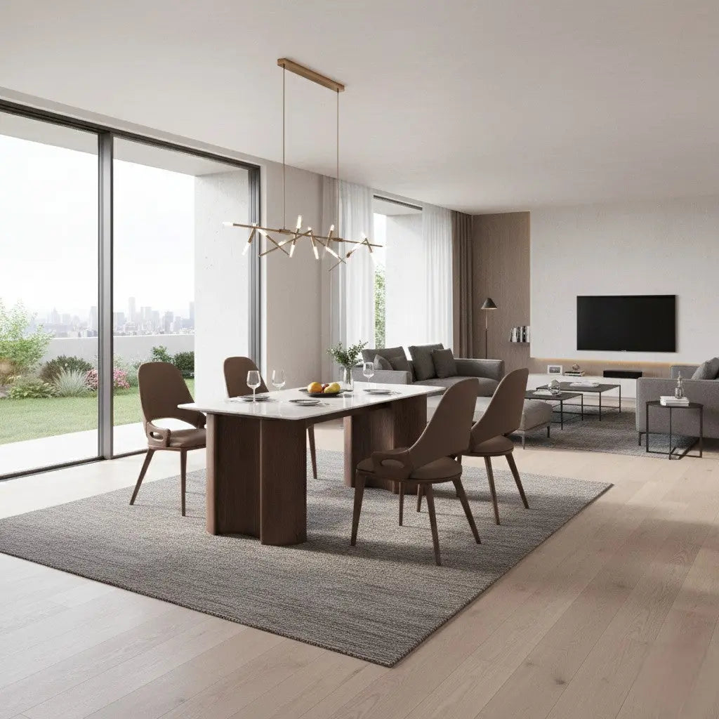 Marble dining table with four upholstered chairs in an open-plan living and dining room