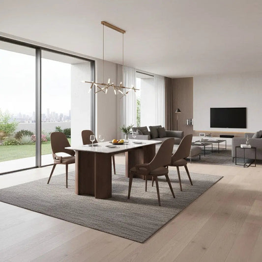 Marble dining table with four upholstered chairs in an open-plan living and dining room