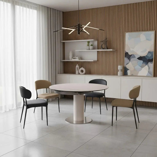 Round sintered stone dining table with a pedestal base and black and khaki chairs in a modern dining room