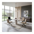 Pale pedestal dining table and swivel chairs in a bright dining room