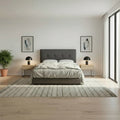 Dark grey tufted bed, front view in a bedroom