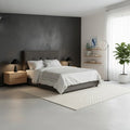 Dark grey tufted bed in a bright bedroom