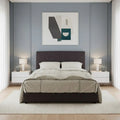 Dark button-tufted bed, front view against a pale wall
