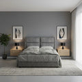 Grey upholstered bed with padded headboard, front view
