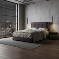 Dark grey tufted bed in a room with tall dark-framed windows