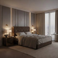 Brown tufted bed beside a window in a softly lit bedroom