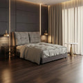 Grey upholstered bed in a dark bedroom
