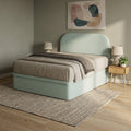 Mint upholstered storage bed in a bedroom, angled view